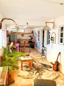 科苏梅尔Mi Refugio Dive House的客厅配有桌子和吉他