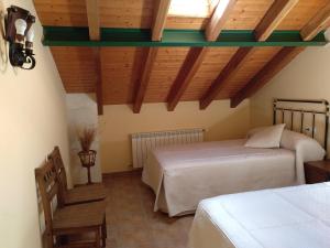AcebedoCasa Rural El Pinar的一间卧室设有两张床和木制天花板