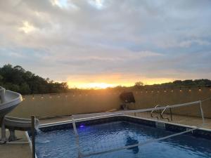 MarshfieldDeer Run Estate LLC的屋顶上的游泳池,背景是日落