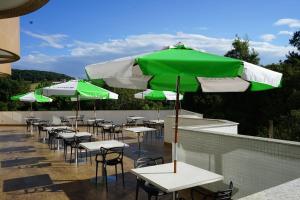 Erval VelhoHotel do Gringo的一排配有绿色和白色遮阳伞的桌椅