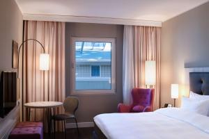 不莱梅不来梅丽笙布鲁酒店的酒店客房设有床和窗户。