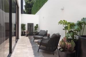 墨西哥城Leonora Luxury Plus by Viadora的庭院设有椅子和盆栽植物
