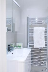 伦敦Executive Bright and Airy Studio Apartment in Sydenham的白色的浴室设有水槽和镜子