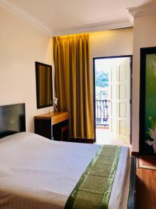 伯恩仓Hotel Chua Gin @ Brinchang Centre的一间卧室配有一张床、一张书桌和一个窗户。