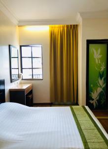 金马仑高原蔡氏杜松子酒酒店的一间卧室配有一张床、一张书桌和一个窗户。