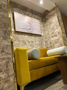 吉达Moments Hotel的砖墙房间里一张黄色的沙发