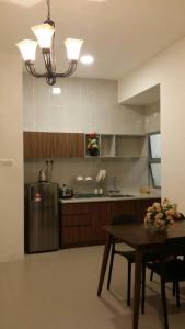 金马仑高原夜市金山三室公寓的厨房配有桌子和不锈钢冰箱。