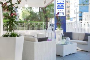 里乔内Hotel Bel Air的阳台的庭院配有白色家具和植物