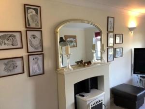 塞尔西Caedwalla House, Selsey的客厅设有壁炉和镜子