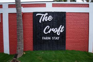 杜蒂戈林The Croft Resort - Premium Farm Stay的砖楼边的标志