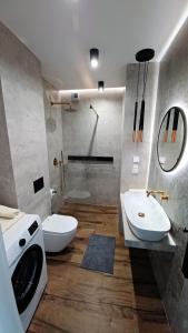 卡托维兹Kima Apartament Bażantów 40的一间带水槽、卫生间和洗衣机的浴室