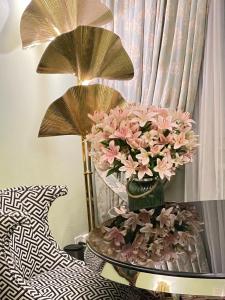 日内瓦亚德里亚提卡酒店的一张桌子,上面有花瓶,上面有粉红色的花