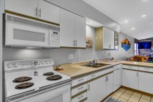 布兰森Fairway Heights condo的厨房配有白色橱柜和白色炉灶烤箱。