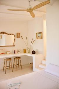 Sant Francesc de s'EstanyLa Pandilla Ibiza的白色的客房配有吊扇和书桌。