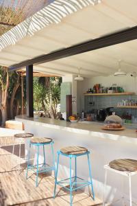 Sant Francesc de s'EstanyLa Pandilla Ibiza的厨房在柜台前设有三把凳子