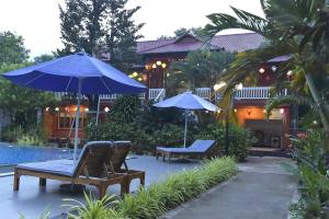 富国Rain Forest Resort Phu Quoc的房屋旁的天井配有椅子和遮阳伞