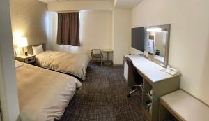 三原市亚萨酒店的酒店客房配有两张床和一张书桌