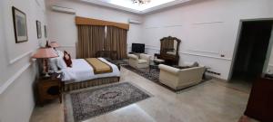 拉希迈尔汗Etihad Club by Faletti's Hotel的酒店客房配有一张床、一张沙发和椅子。