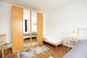 博尔滕哈根Dünenblick Wohnung 48的一间卧室配有一张床和一个大型木制橱柜