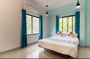 科泽科德Ecoville suites的一间卧室配有一张蓝色墙壁和窗户的床
