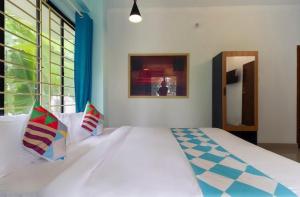 科泽科德Ecoville suites的卧室配有一张带彩色枕头的大型白色床。