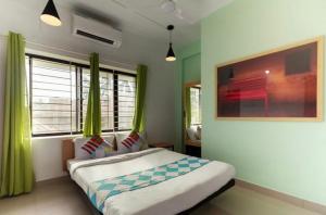 科泽科德Ecoville suites的一间卧室配有一张带绿色窗帘的大床