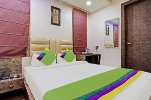 古瓦哈提Itsy By Treebo - Ransu Residency的卧室配有一张带彩色枕头的大型白色床。