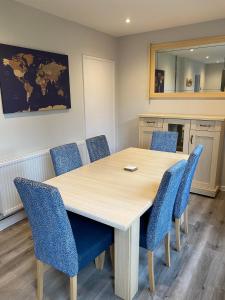 斯塔福德Spacious & modern 3 bed house的一间会议室,配有木桌和蓝色椅子
