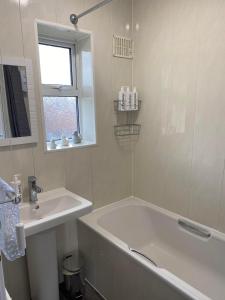 斯塔福德Spacious & modern 3 bed house的白色的浴室设有浴缸和水槽。