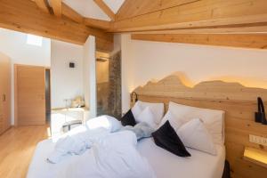 莫埃纳Attico Faloria Luxury的卧室配有一张白色大床和木制天花板