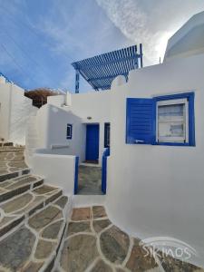 锡基诺斯岛Sikinos Summer Nest的白色的房子,有蓝色的门和楼梯