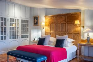 圣马丹德雷La Baronnie Hôtel & Spa - Teritoria的一间卧室配有一张大床和木制床头板