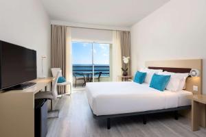 卡帕里卡海岸TRYP by Wyndham Lisboa Caparica Mar的酒店客房设有一张床,享有海景。