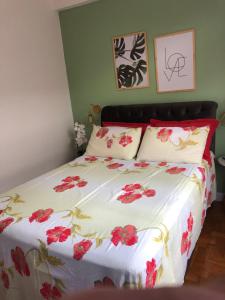 彼得罗波利斯Apartamento Centro Histórico de Petrópolis 200Mbps de internet的一间卧室,床上有红色的鲜花