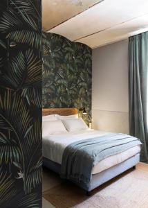切尔维亚Antica Dimora Le Misure的一间卧室配有一张床和热带壁纸