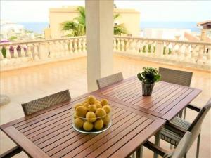 Cala Anguila*****Villa de Món max. 8 Personen, Meerblick + Pool的阳台上的木桌上放着一盘水果
