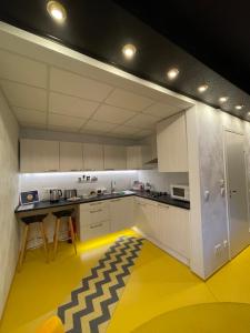 派德Guest House Bermuuda Apartment的厨房配有白色橱柜和黄色地板