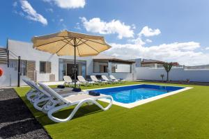 卡勒达德福斯特Luxury Villa Perla的房屋旁的游泳池配有椅子和遮阳伞