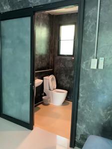 Chai NatBaan Tonjaeng Resort的一间带卫生间和玻璃门的浴室