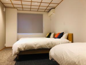 京都Corner6的带两张床和投影屏幕的房间