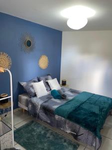 圣路易斯Le Coin Trankil的一间卧室配有一张蓝色墙壁的床