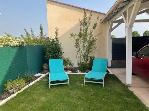 维尔特·圣丹尼斯Chez Jojo & Cassi的两把蓝色椅子坐在院子里的草地上