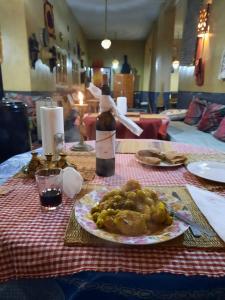 AgoudalKasbah Citoyenne的一张桌子,上面放着一盘食物和一瓶葡萄酒