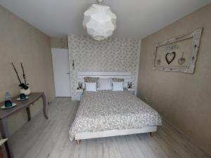 朗通Chambres d'Hotes des Ecureuils的一间卧室配有一张床和一个吊灯