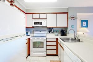 大洋城Hidden Harbour 312C的厨房配有白色橱柜和水槽