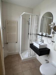 奥斯赛拜-屈隆斯博恩Hotel Poseidon的带淋浴和盥洗盆的浴室