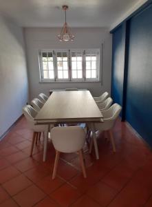 锡尼什Parfum de la Mer的一间带木桌和白色椅子的用餐室
