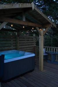 DuddonLuxurious Cottage with hot tub, Lake District的木甲板上的热水浴池,配有凉棚