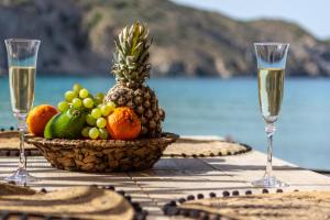 FiropótamosVilos Suites Fyropotamos Beach的桌上一篮水果和酒杯