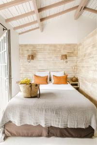 圣马迪拉莫Hôtel Restaurant Les Arnelles的一间卧室配有一张带橙色枕头的大床
